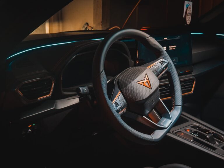 Explore an elegant car cockpit featuring a carbon fiber steering wheel and modern dashboard design.