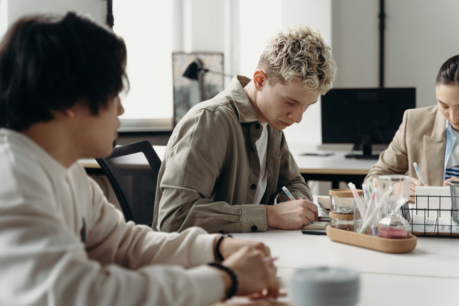 A diverse group of young professionals brainstorming in a contemporary office environment.